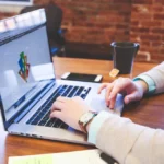 Person using an AI generator on a laptop to draft content at work
