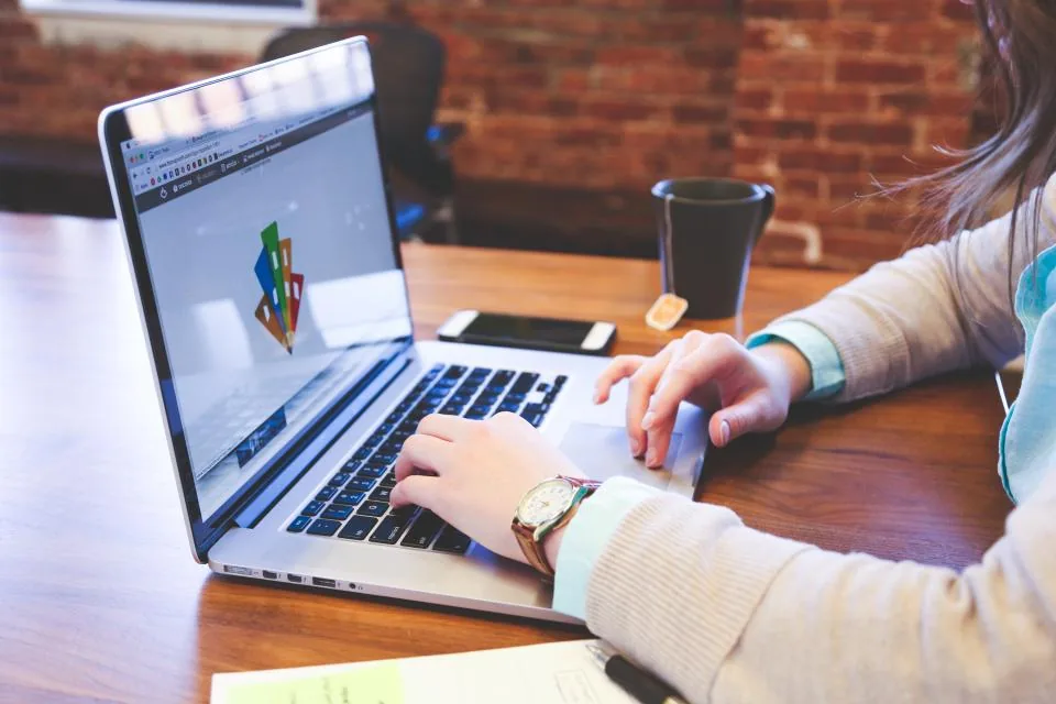 Person using an AI generator on a laptop to draft content at work